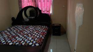 Habitación pequeña con cama con espejo. en Berakah cozy Rentals en Freetown