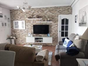un soggiorno con 2 divani e una TV di Casa en pueblo con piscina cerca de Córdoba a Encinarejo De Córdoba