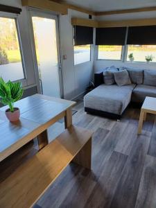 a living room with a couch and a table at Stacaravan 14 met airco vakantiepark de Tien Heugten Schoonloo Drenthe in Schoonloo