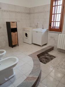a bathroom with a washing machine and a sink at Casa Belvedere in Isnello