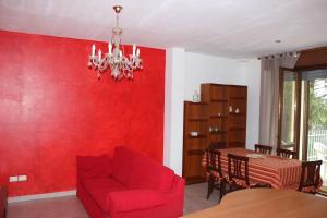 ein Wohnzimmer mit einer roten Wand und einer roten Couch in der Unterkunft Appartamento e giardino Perugia in Deruta