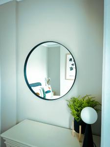 um espelho redondo numa parede branca num quarto em The Grange em Stockton-on-Tees