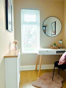 a room with a desk and a window with a mirror at The Grange in Stockton-on-Tees