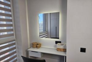 a bathroom with a mirror and a table with a chair at ЖК Комфорт Сити Бизнес, 2 room Apartment 47 in Almaty