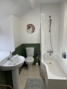a bathroom with a sink and a toilet and a bath tub at Stunning Cottage with Log Burner in Frosterley