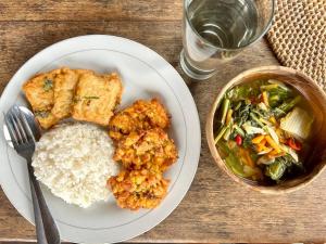 um prato de comida com arroz e uma tigela de comida em D'Ume Bendoel Homestay em Jatiluwih