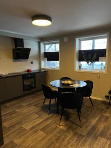 a room with a table and chairs and a kitchen at Your home away from home, apartment 1 in Tromsø