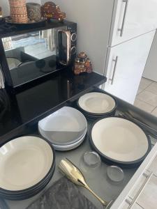 four white plates sitting on a counter in a kitchen at Cosy Double Room in Dartford