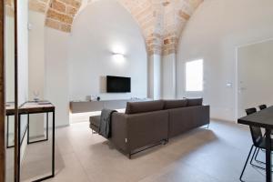 ein Wohnzimmer mit einem Sofa und einem TV in der Unterkunft Chapeau Apartment - Lecce Selection in Squinzano