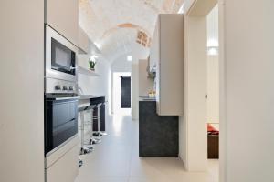 eine Küche mit weißen Wänden und eine Decke mit einem TV in der Unterkunft Chapeau Apartment - Lecce Selection in Squinzano