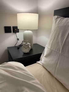 1 dormitorio con 1 cama con lámpara y reloj en شقة انيقة ستديو في حي السليمانية( دخول ذاتي) en Riad