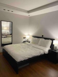 1 dormitorio con 1 cama con 2 lámparas y espejo en شقة انيقة ستديو في حي السليمانية( دخول ذاتي) en Riad