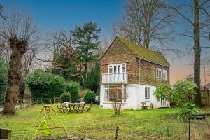 a small house with a picnic table and a table at 3 bed house near Gatwick and Redhill in Bletchingley