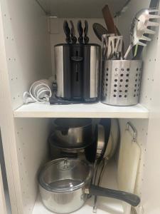 ein Küchenregal mit einer Kaffeemaschine und Küchenutensilien in der Unterkunft Le Sami in Lausanne