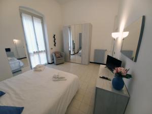 Cette chambre comprend un lit avec un vase orné de fleurs. dans l'établissement CASA MARE, à Gênes