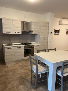 a kitchen with a table and chairs and a stove at Casa sul Conca in San Giovanni in Marignano