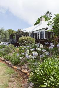 a house with a garden with purple flowers at The Retreat Tamborine Mountain in Mount Tamborine