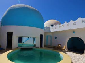 a swimming pool in a house with a blue dome at la maison blanche du lac in Niaga
