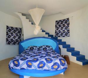a blue bed in a room with a staircase at la maison blanche du lac in Niaga