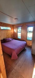 Cabañas castro chiloe في Punahuel: غرفة نوم بسرير كبير في منزل