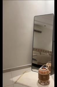 een spiegel in een kamer met een vaas op de vloer bij شقة حي العقيق غمام in Riyad