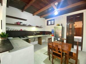 a kitchen with a table and a refrigerator at Casa Amiga Jeri in Jericoacoara