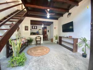 a living room with a staircase and a television at Casa Amiga Jeri in Jericoacoara