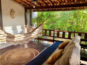a hammock in a room with a view of the forest at Casa Amiga Jeri in Jericoacoara