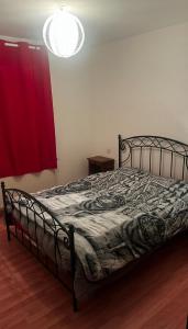 een slaapkamer met een bed en een rood gordijn bij le Gite de illian in Saint-Michel