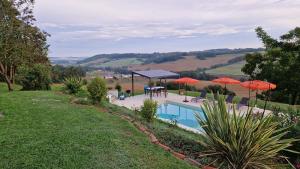 a view of a pool with umbrellas at Le Peyroutet in Cazaux-Villecomtal