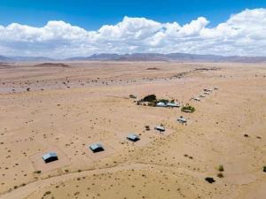 an aerial view of a desert with tents in it at Little Sossus Campsite in Maltahöhe