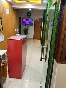 a lobby with a red counter and green walls at HOTEL DADO'S INN in Panaji