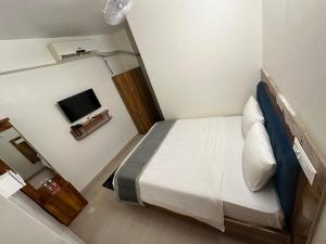 a small bedroom with a bed and a television at HOTEL DADO'S INN in Panaji