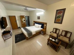 帕納吉的住宿－HOTEL DADO'S INN，一间卧室配有一张床和一台电视。