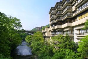 a river in front of a building and a bridge at Yamanakaonsen Hanamurasaki in Kaga