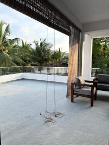 a room with a swing and a bench on a balcony at 2 bedroom beautiful shared villa with private kitchen and parking in Siolim