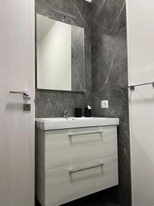 een badkamer met een witte wastafel en een spiegel bij Casa sul Conca in San Giovanni in Marignano