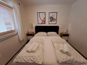 een slaapkamer met een bed met handdoeken en slippers erop bij Aida in Novi Vinodolski