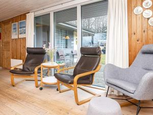 6 person holiday home in Glesborg في Bønnerup: غرفة معيشة فيها ثلاثة كراسي وطاولة