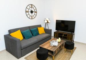 a living room with a gray couch with colorful pillows at Sias Apartment in Alexandroupoli