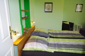 ein Schlafzimmer mit einem Bett mit einer grünen Wand in der Unterkunft Ferien-Wohnung am Menzer-Park in Neckargemünd