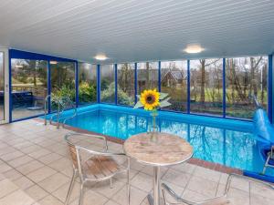 una casa con una piscina con una mesa y un girasol en 8 person holiday home in Fars, en Ertebølle