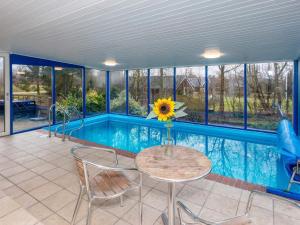 a house with a pool with a table and a sunflower at 8 person holiday home in Fars in Ertebølle