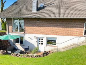 ein Haus mit einer Terrasse und einem Sonnenschirm in der Unterkunft Am Grünenplatz 63 in Wermelskirchen