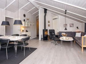 a living room with tables and chairs and a couch at 6 person holiday home in Hemmet in Falen