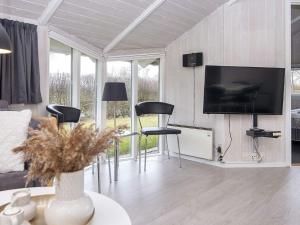 a living room with a tv and some chairs at 6 person holiday home in Hemmet in Falen