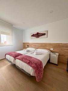 a large bedroom with a large bed with red blankets at Alojamientos Robustiana in Santander