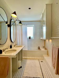 a bathroom with two sinks and a tub and a mirror at Helle Altbauwohnung mit Balkon im Briller Viertel in Wuppertal