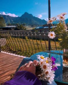 une personne assise à une table avec un bouquet de fleurs dans l'établissement Hotel Garbani, à Kazbegi