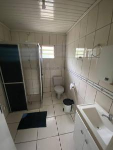 een badkamer met een douche, een toilet en een wastafel bij Casa d campo, pátio amplo, cercado. 5min do centro in Rolante